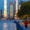 a person walking on a bridge over water with tall buildings in the background