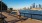 a person riding a bicycle on a boardwalk near a body of water